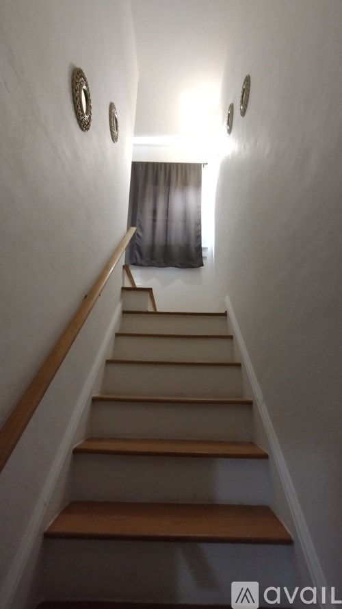 A staircase with wooden steps and a light on the wall.