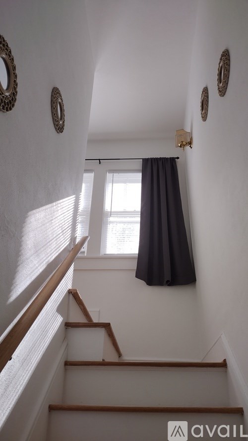 A staircase with a window and curtains.