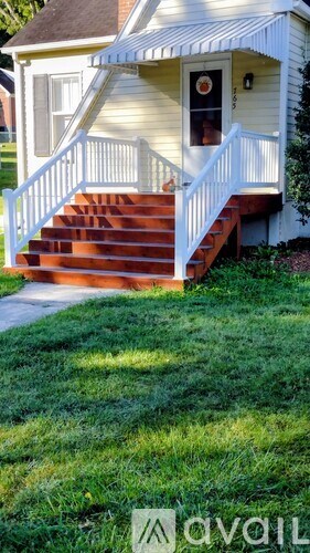 A small house with a white porch and stairs.