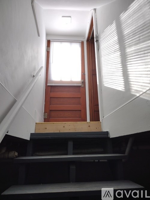 A stairway with a wooden handrail and a landing.