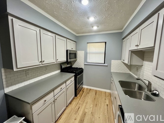 A kitchen with white cabinets and a stainless steel counter.