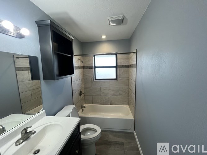 A bathroom with a toilet, sink, and bathtub.