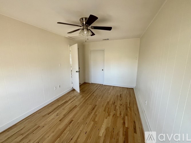 A room with wooden floors and a ceiling fan.