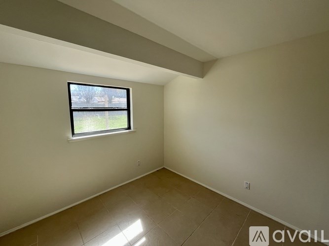 A room with a window and tiled floor.