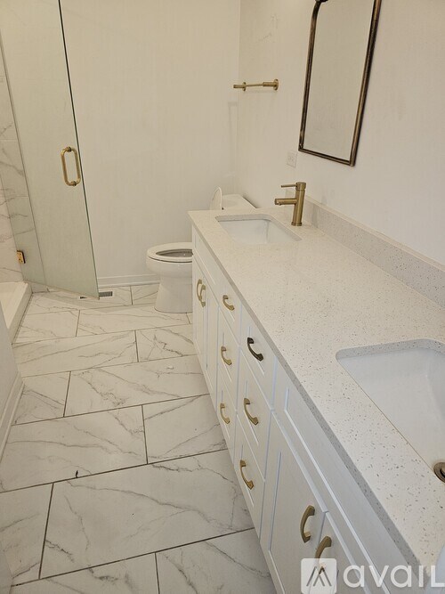 A bathroom with a marble floor and white walls.