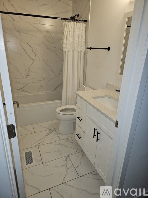 A bathroom with a marble floor and white walls.