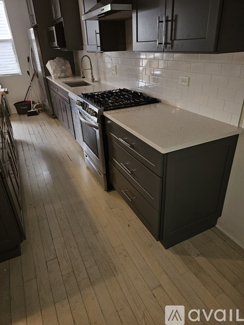 A kitchen with black cabinets and a white countertop.