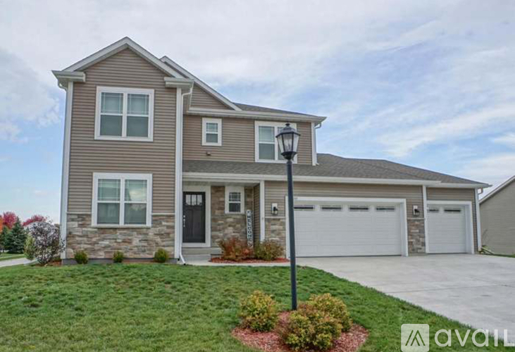 A house with a grey roof and a white garage door.
