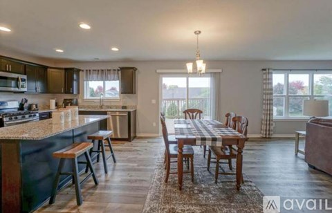 A kitchen with a dining table and chairs.