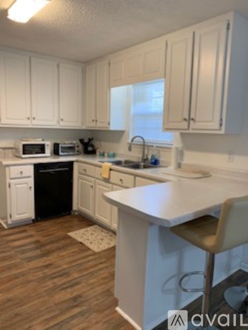 A kitchen with white cabinets and a white island.