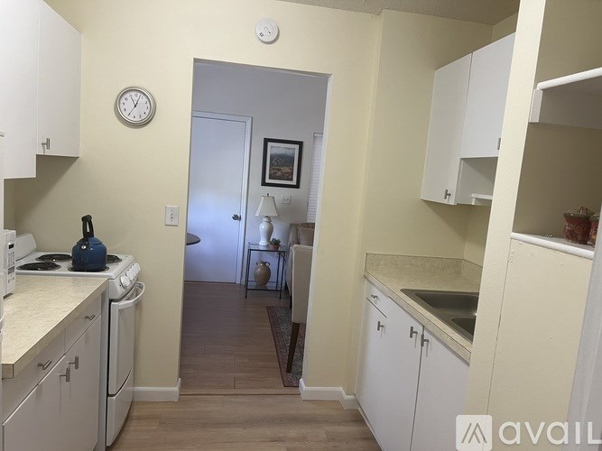 A kitchen with white cabinets and a clock on the wall.