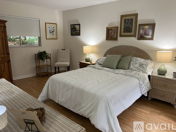 A bedroom with a large bed and a chair.