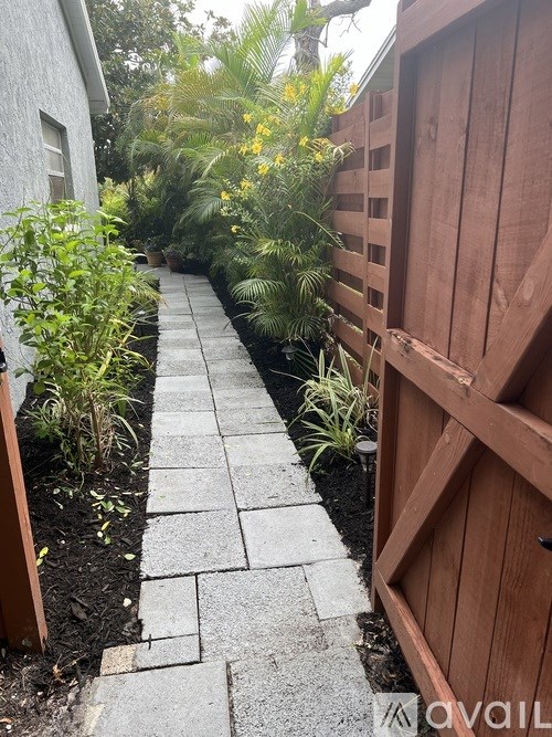 A wooden fence is on the right side of a garden path.