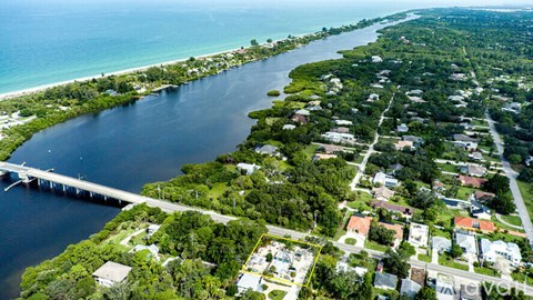 A bridge spans a body of water with a residential area on the other side.