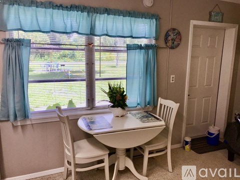 A dining room with a table and chairs.