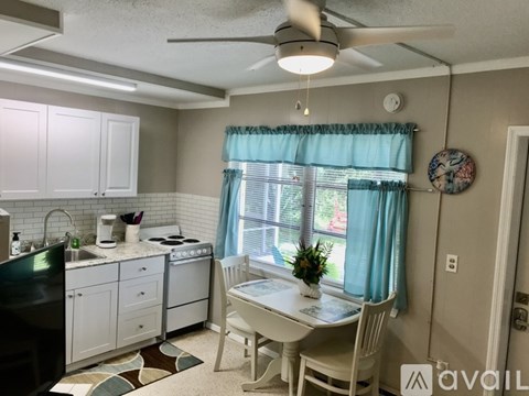 A kitchen with a dining table and chairs.