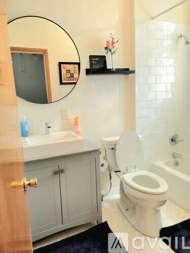 A bathroom with a toilet, sink, and mirror.