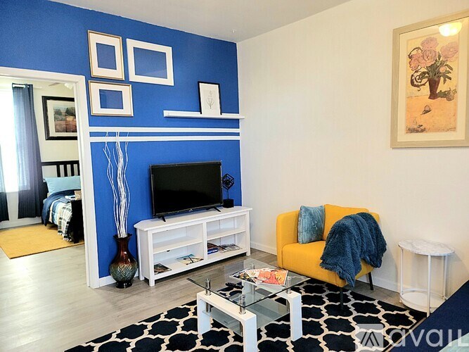 A living room with a blue wall and a television.
