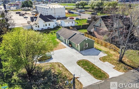A bird's eye view of a green building with a white building in the background.