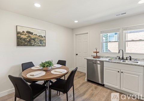 A kitchen with a table set for four and a painting on the wall.