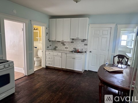 A kitchen with white cabinets and a wooden table.