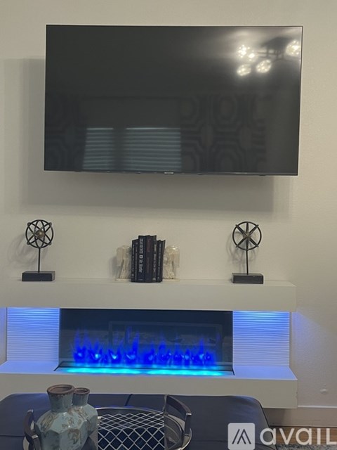 A modern living room with a fireplace and a television mounted above it.