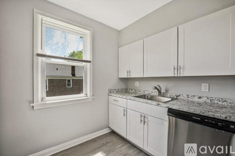 A kitchen with white cabinets and a granite countertop.
