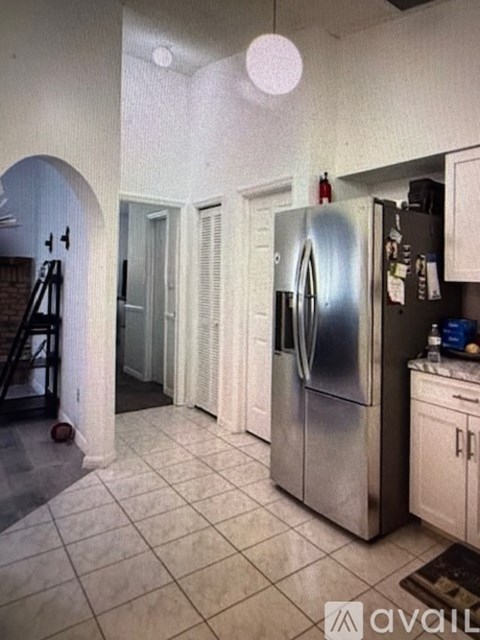 A kitchen with a refrigerator and cabinets.