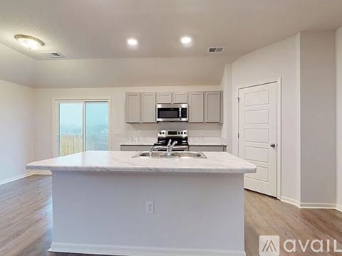 A kitchen with white cabinets and a marble countertop.