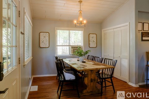 A dining room with a wooden table and chairs.