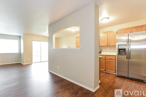 A kitchen with wooden cabinets and a refrigerator.