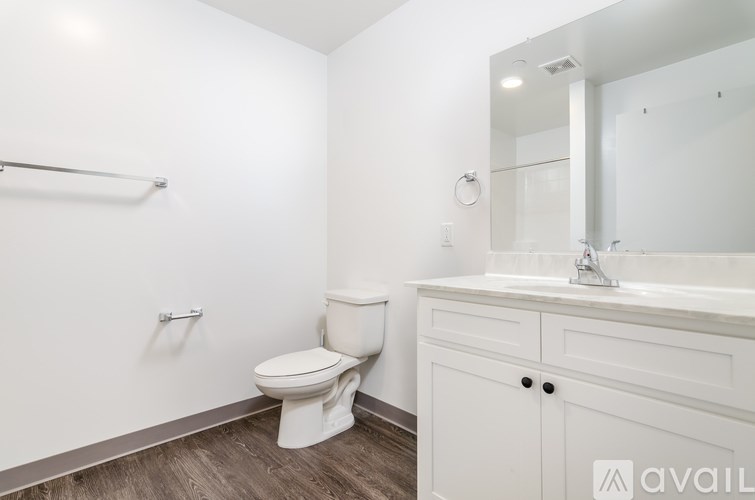 A white bathroom with a toilet, sink, and mirror.