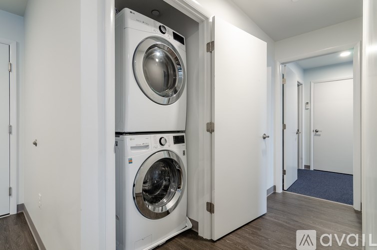 A washing machine is built into a wall in a laundry room.