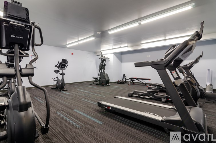 A gym with treadmills, exercise bikes, and other equipment.