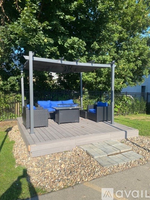 A patio with a white canopy and blue cushions.