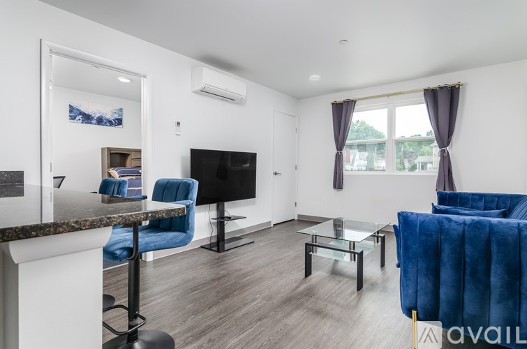 A living room with a blue chair and a black television.