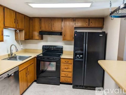 A kitchen with wooden cabinets and black appliances.
