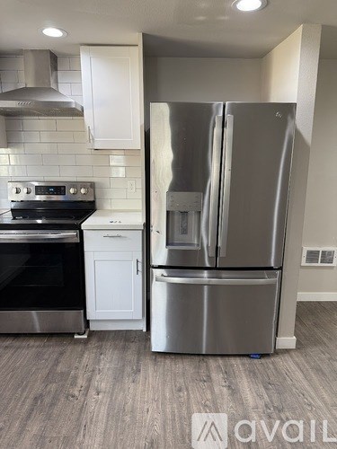 A modern kitchen with a stainless steel refrigerator and oven.