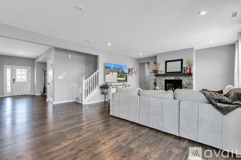 A spacious living room with a white couch and wooden floors.