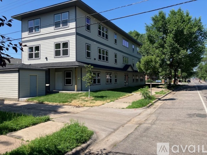 A two-story building with a grey and white exterior is available for rent.
