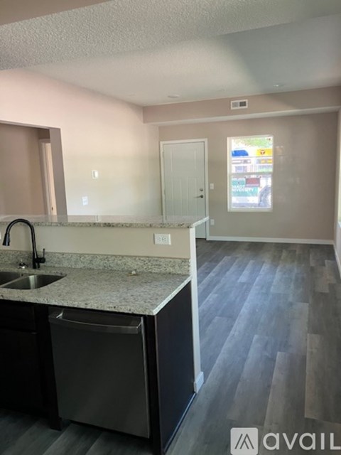 A kitchen with a granite countertop and a dishwasher.