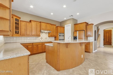 A kitchen with wooden cabinets and a marble countertop.