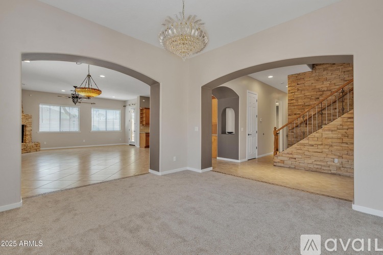 A spacious living room with a staircase leading to the upper floor.