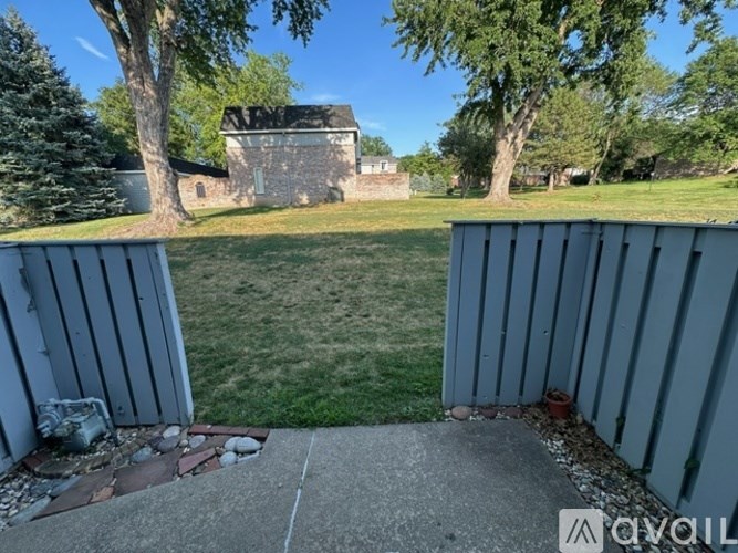 A backyard with a concrete slab and a building in the background.
