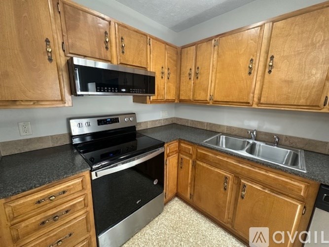 A kitchen with wooden cabinets and a black stove top oven.