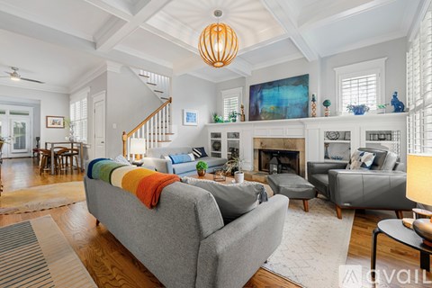 A living room with a grey couch and a fireplace.