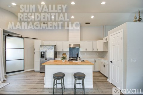 A kitchen with a center island and bar stools is shown in a Sun Valley Residential Management LLC listing.