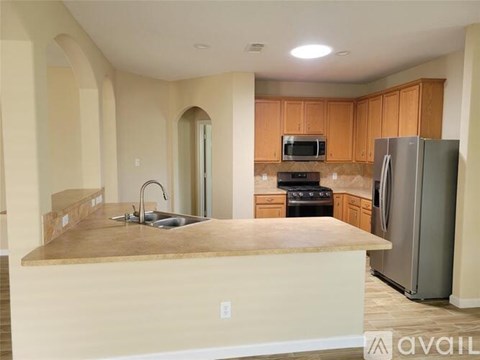 A kitchen with a sink, stove, and refrigerator.