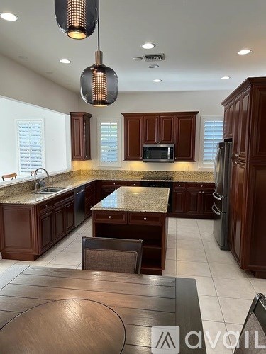 A modern kitchen with dark wood cabinets and a granite countertop.
