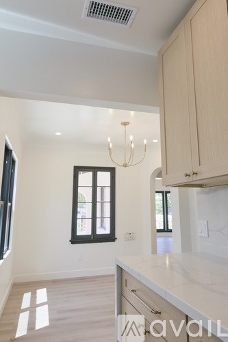 A kitchen with a white counter top and wooden cabinets.